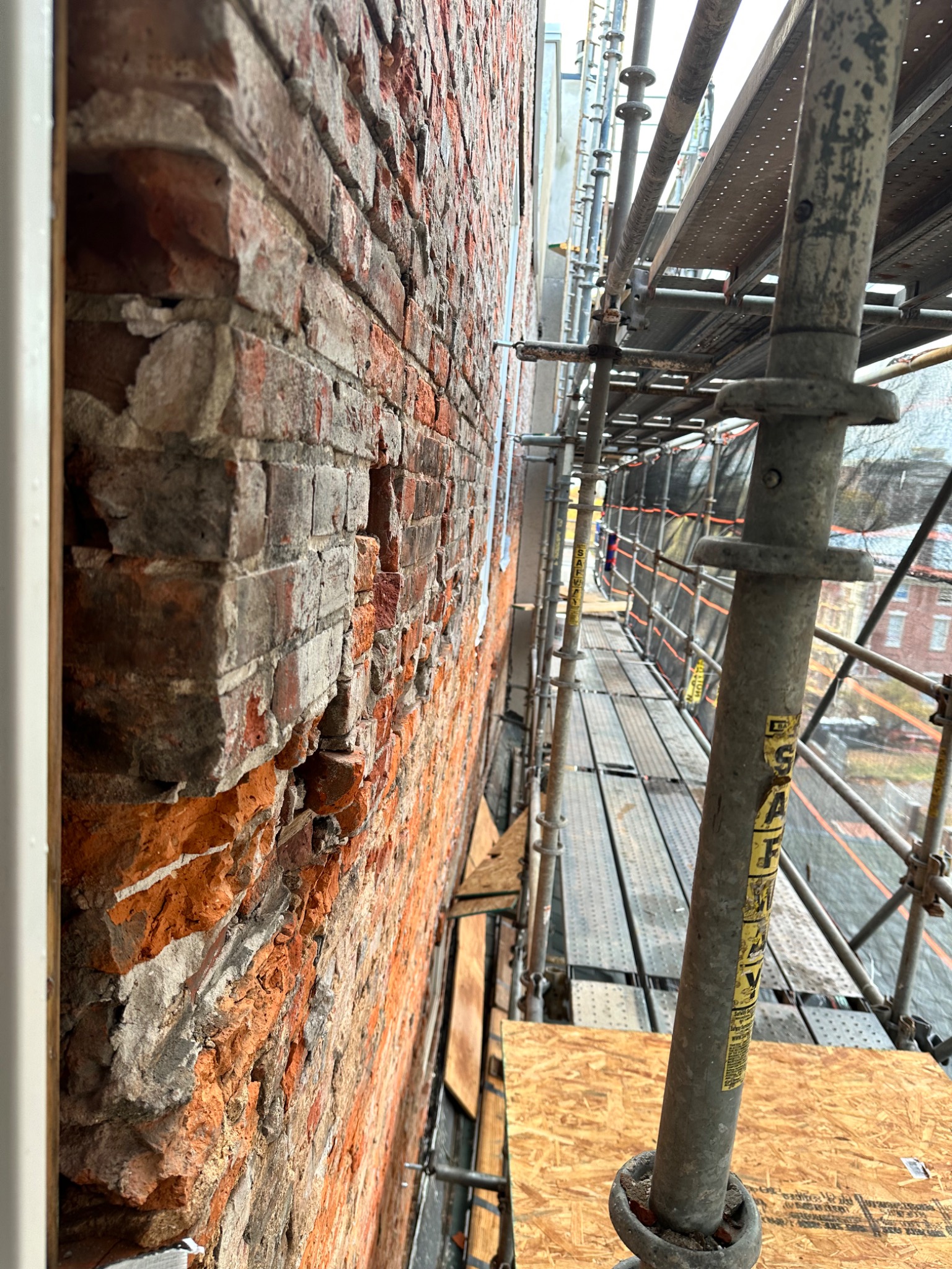 Close view of exposed masonry and multi-story scaffolding at the Old City project